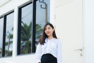 close up attractive adult business woman asian girl with happy and smile against white concrete wall office.