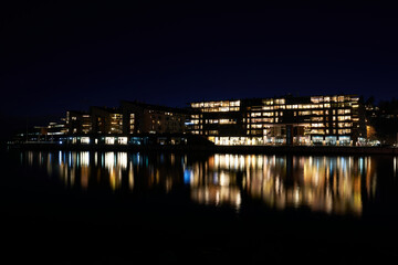 Fototapeta na wymiar Lysaker Brygge by night. Long exposure to smooth out the water and to capture the dark parts without noise. Shot at Oslo, Norway, from the Bygdøy side Sollerud boat building. 