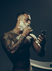 Handsome sexy man shaving. Shaving man with foam cream on face.