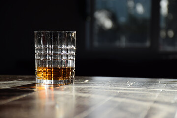 A glass of golden whiskey with afternoon sunlight highlighting the liquor colour
