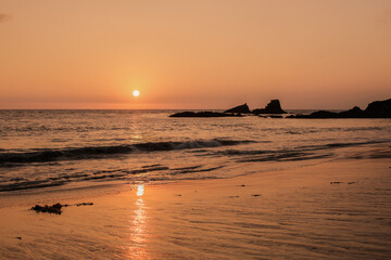 Sunset with rocks sticking out from the ocean