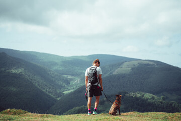 man is contemplating the forest with his dog