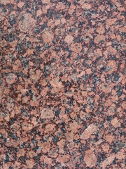 a granite fragment with a polished surface and a smoothed natural stone texture vertical image, marble background for use in interior design, industry and decor