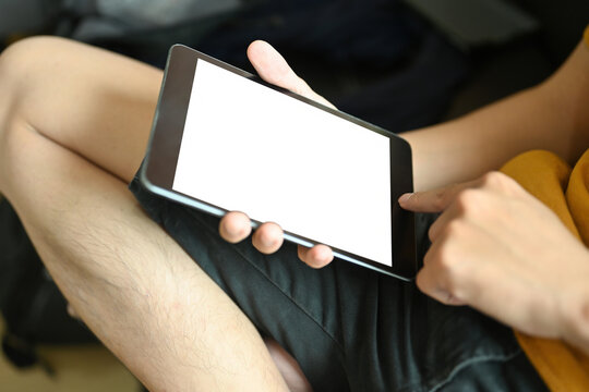 Close-up image of a young man relaxing with a white blank screen digital tablet.