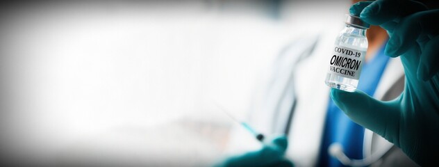 Omicron variant of SARS-CoV-2. New B.1.1.529 Variant of concern. Doctor holds vaccine against new...