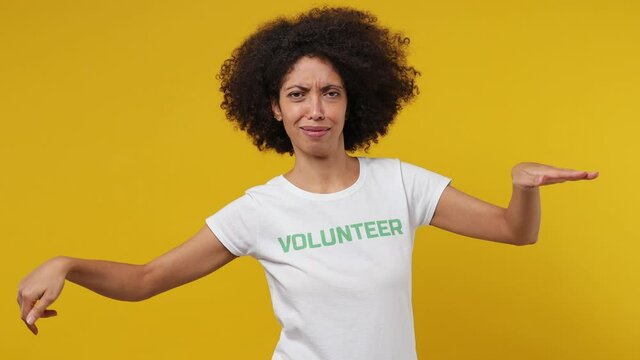 Shocked upset young black woman 20s in white t-shirt green title volunteer swim find plastic bag say ask what omg no way isolated plain yellow background studio portrait. Stop nature garbage concept