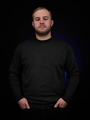 vertical portrait  blond man on a dark background, in a jacket