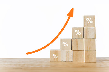 wooden blocks with percentage sign and orange arrow up for business and financial growth, interest...