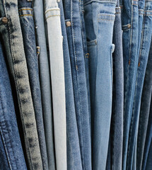 jeans of different colors and models on a hanger in a supermarket