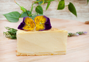 Cheesecake slice with edible flowers and selective focus