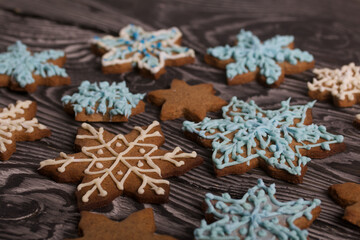 Gingerbread cookies in the shape of a snowflake. Decorated with sugar glaze. Gingerbread cookies in the shape of a snowflake. Lie on black boards. Close-up shot.
