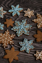Gingerbread cookies in the shape of a snowflake. Decorated with sugar glaze. Gingerbread cookies in the shape of a snowflake. Lie on black boards. Close-up shot.