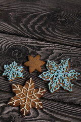 Gingerbread cookies in the shape of a snowflake. Decorated with sugar glaze. Gingerbread cookies in the shape of a snowflake. Lie on black boards. Close-up shot.