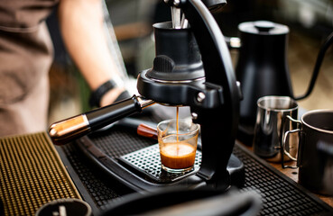 Barista making espresso with a manual coffee maker.