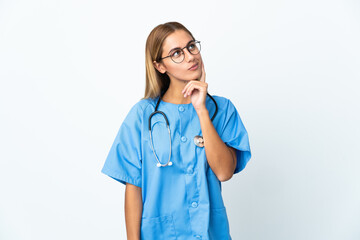 Surgeon doctor woman over isolated white background having doubts while looking up