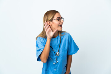 Surgeon doctor woman over isolated white background listening to something by putting hand on the ear