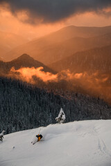 skier rides slope against the backdrop of winter mountain landscape with bright sky