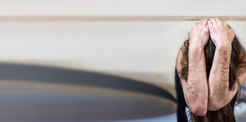 unrecognizable woman beats her hands together over her head in despair, heavy cuts and scars of...