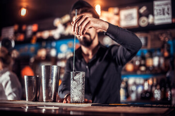 Expert barman formulates a cocktail in the pub
