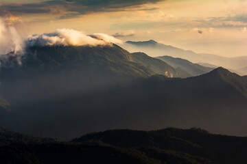 beautiful high mountain scenery covered with clouds and the evening sun