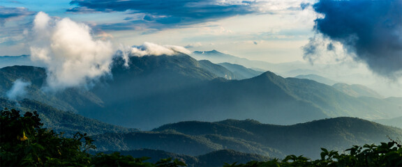 beautiful panorama high mountain scenery covered with clouds and the evening sun