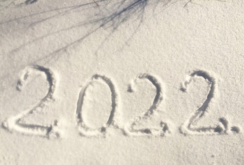 The inscription on the snow New 2022. Christmas Eve, winter day with snowfall. flying snowflakes. there are shiny winter snowdrifts on the ground, New Year's mood outside