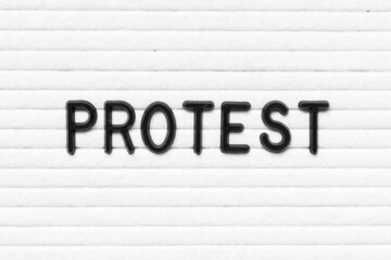 Black letter in word protest on white felt board background