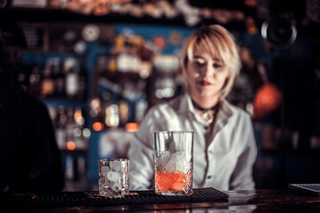Girl bartender mixes a cocktail at the alehouse