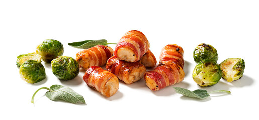 Appetizing Chicken breast wrapped in bacon, garnished with brussel sprout and sage leaves. Holiday food. Isolated on white background. 