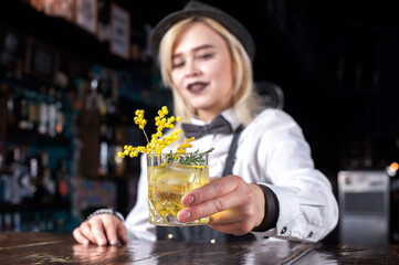 Girl barman makes a cocktail on the alehouse