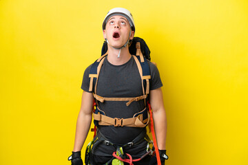 Young rock climber Brazilian man looking up and with surprised expression