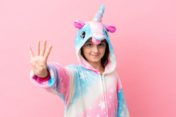 Little caucasian woman wearing a unicorn pajama isolated on pink background happy and counting four with fingers