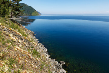 Lake Baikal, Russia. Rocky steep shore on the lake and clear water. Beautiful landscape.