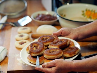 The process of home cooking whites. Elderly woman is hands hold a plate with whites on the background of the kitchen table. Healthy homemade food.