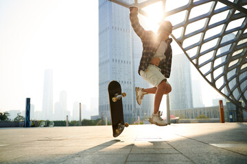 teenage asian boy skateboarding outdoors © imtmphoto