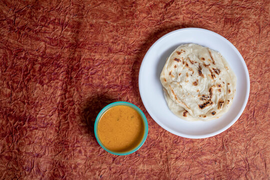 Parotta with chicken curry on a white plate. is a delicacy from the state of Kerala