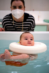 Baby enjoying in the jacuzzi with his mother. Spa for babies. Hydrotherapy session for children....
