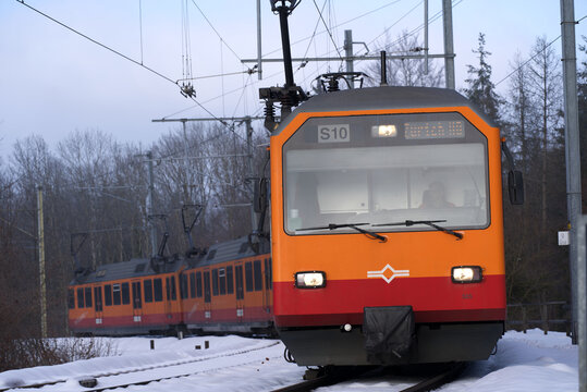 Orange and red SZU train at railway station of local mountain Uetliberg on a cold and foggy winter day. Photo taken December 18th, 2021, Zurich, Switzerland.