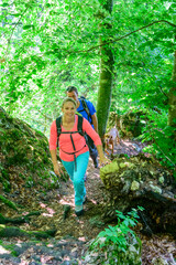 Junge Leute wandern gutgelaunt im schattigen Wald