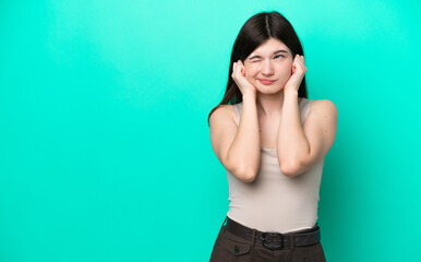 Young Russian woman isolated on green background frustrated and covering ears