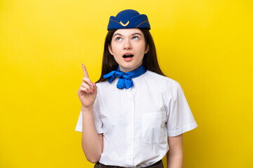 Airplane stewardess Russian woman isolated on yellow background thinking an idea pointing the finger up