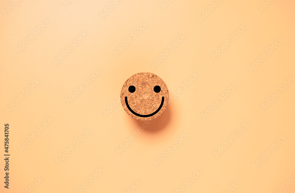 Poster smile face on circle wooden block on orange background for happy mindset concept.