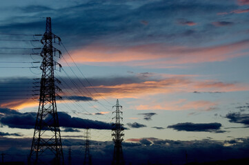 低い雲と夕焼け空の中に立つ鉄塔