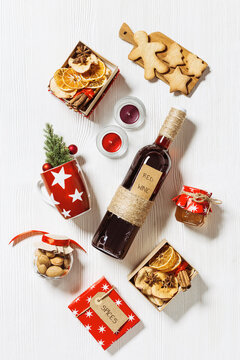 Mulled wine Ingredients, christmas holiday hot winter drink, bottle red wine, dried fruits, candy, honey, spices, red mug on white wood