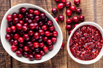 Red cranberries on wooden background. Brries in a bowl.