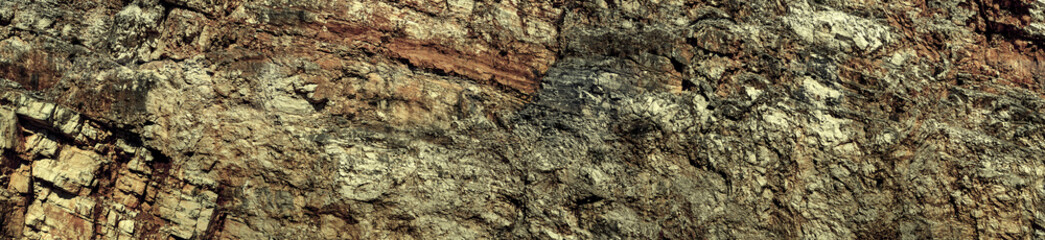 Grungy cragged bumpy pitted cavity stone facade, split layer gap.Ruined cracked shattered worn rough hiking canyon.Old ragged grunge steep marble cliff. Grand vintage crannied damaged impressive gorge