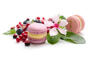 A scattering of juicy berries, flower and macarons.
