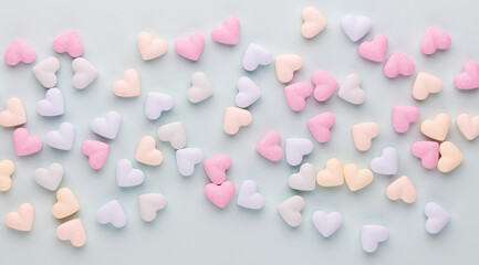 Composition with candy hearts on pastel blue background.