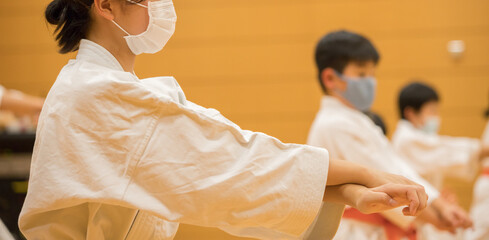 教室で空手を練習している学生たちの姿