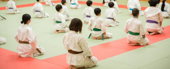 教室で空手を練習している学生たちの姿